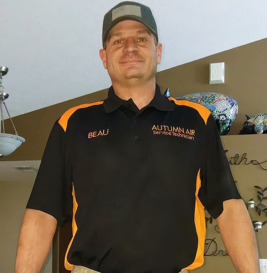 Man wearing a black and orange Polo shirt with 'BEAU' and 'AUTUMN AIR Service Technician' embroidered, and a baseball cap.